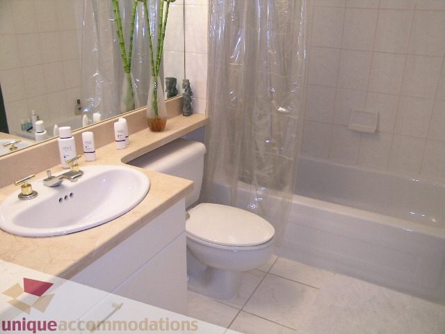 Modern bathroom with white fixtures, marble countertop, and a bathtub. - 1306-388 Drake St, Vancouver Downtown