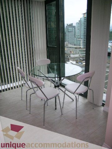 Furnished dining area with glass table, white chairs, and city view. - 905 - 1331 West Georgia Street, Vancouver Downtown