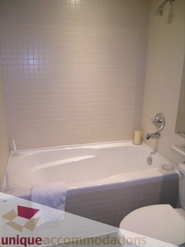 Bathroom with white bathtub and tiled walls. - 503-1072 Hamilton St., Vancouver Downtown