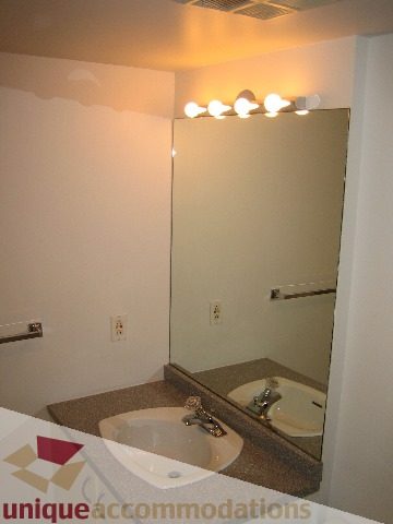 Furnished bathroom with modern sink, granite countertop, and wall-mounted lights. - 1906 - 1060 Alberni Street, Vancouver Downtown