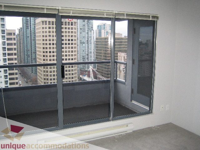 Bright living room with large windows offering a stunning city view. - 1906 - 1060 Alberni Street, Vancouver Downtown