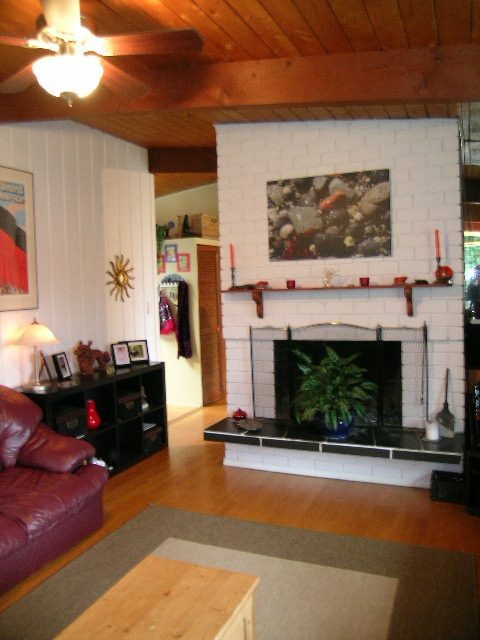 Living room with hardwood floors, brick fireplace, and leather couch. - 433 Fairway Drive, North Vancouver