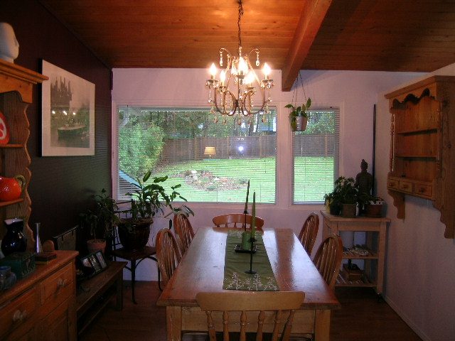 Dining room with wooden table, green runner, and large windows showing a city view. - 433 Fairway Drive, North Vancouver