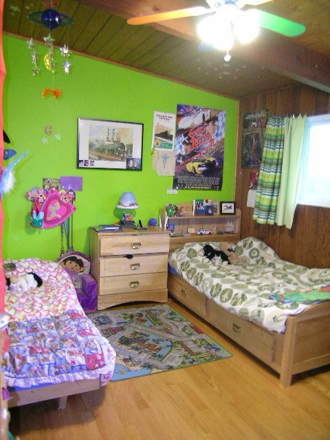 Bright bedroom with green walls, wooden floors, and a colorful bedspread. - 433 Fairway Drive, North Vancouver