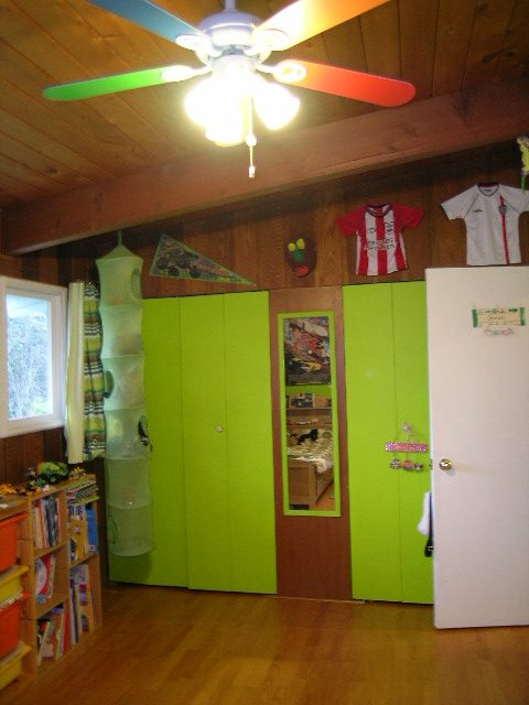 Bright children's bedroom with green cabinets, hardwood floors, and a ceiling fan. - 433 Fairway Drive, North Vancouver