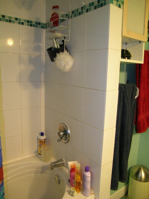Bathroom with white tiles, shower caddy, and bath products. - 433 Fairway Drive, North Vancouver