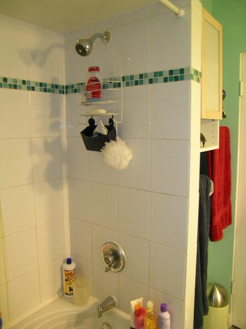 Shower with white tiles, green accent tiles, and hanging toiletries. - 433 Fairway Drive, North Vancouver