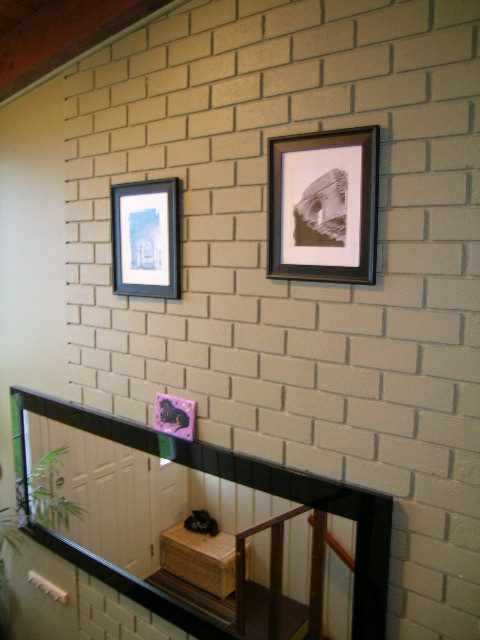 Entryway with brick wall, framed artwork, and wooden bench. - 433 Fairway Drive, North Vancouver
