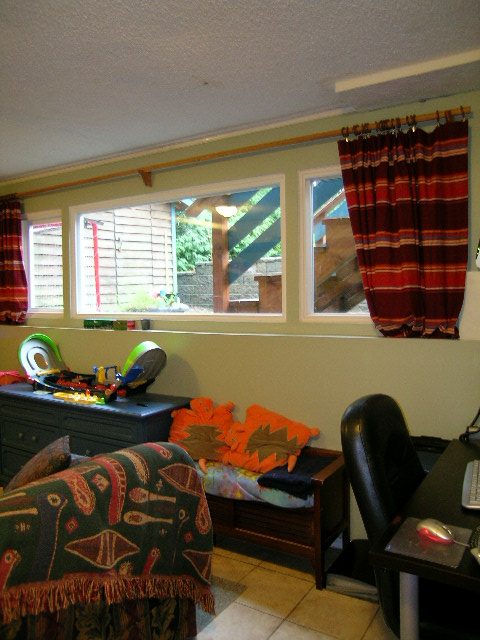 Bright bedroom with wooden bench, colorful curtains, and a view of the backyard. - 433 Fairway Drive, North Vancouver