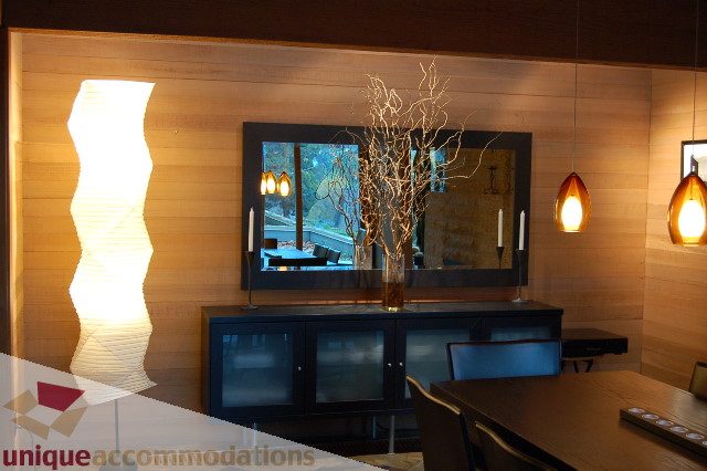 Furnished living room with wooden walls, modern lighting, and a city view. - 6290 Collingwood Street, Vancouver West Side