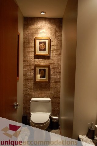 Bathroom with mosaic tile wall, framed art, and modern toilet. - 6290 Collingwood Street, Vancouver West Side