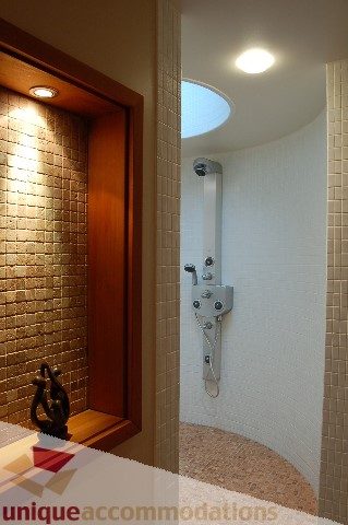 Modern bathroom with curved shower and brick accent wall. - 6290 Collingwood Street, Vancouver West Side