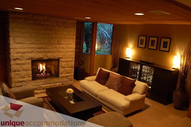 Furnished living room with stone fireplace, modern furniture, and large windows. - 6290 Collingwood Street, Vancouver West Side