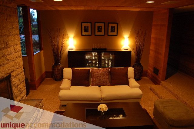 Furnished living room with modern furniture, warm lighting, and a glass display cabinet. - 6290 Collingwood Street, Vancouver West Side