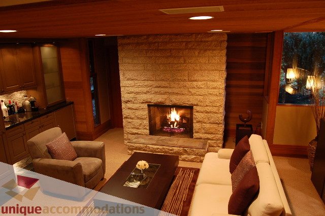 Furnished living room with stone fireplace and modern furnishings. - 6290 Collingwood Street, Vancouver West Side
