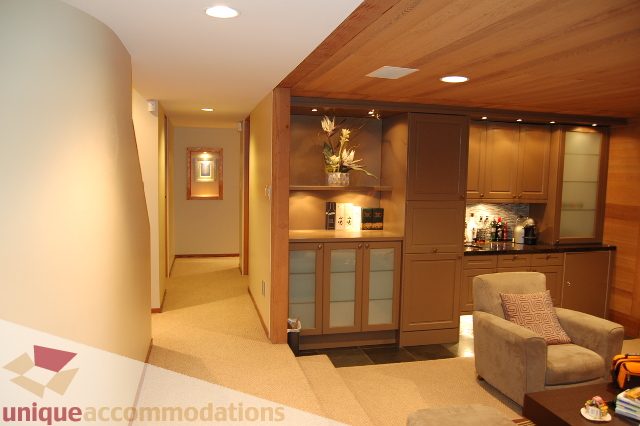 Furnished living room with modern decor, wooden cabinets, and a cozy sofa. - 6290 Collingwood Street, Vancouver West Side