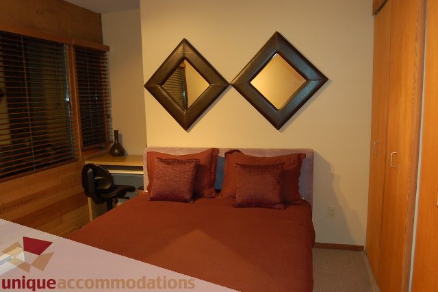Furnished living room with two diamond-shaped mirrors and a cozy sofa. - 6290 Collingwood Street, Vancouver West Side