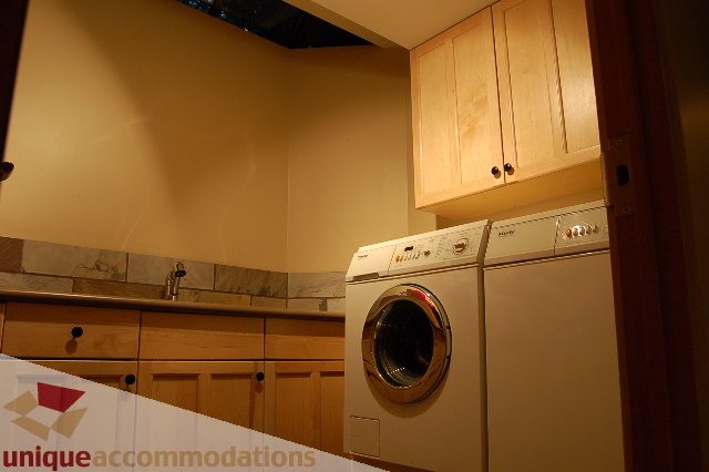 Bright kitchen with light wood cabinets and stainless steel appliances, showcasing a modern and clean design.