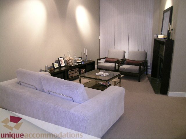 Furnished living room with modern furniture, neutral tones, and a cozy ambiance. - 1430 Strathmore Mews, Vancouver Downtown