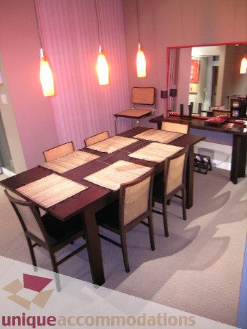 Dining area with wooden table and chairs, modern decor, and hanging lights. - 1430 Strathmore Mews, Vancouver Downtown