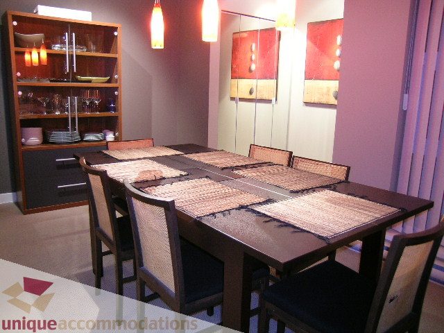Furnished dining area with modern chairs and wooden table, warm lighting. - 1430 Strathmore Mews, Vancouver Downtown