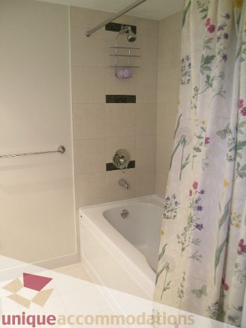 Bathroom with floral shower curtain and modern fixtures. - 1430 Strathmore Mews, Vancouver Downtown