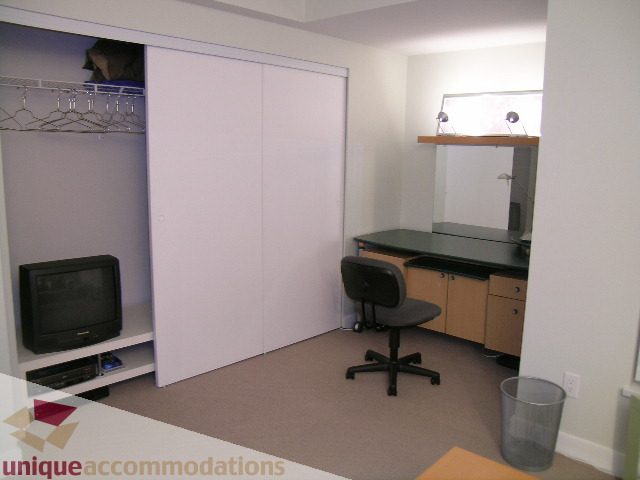 Bright bedroom with sliding closet doors and desk area. - 1430 Strathmore Mews, Vancouver Downtown