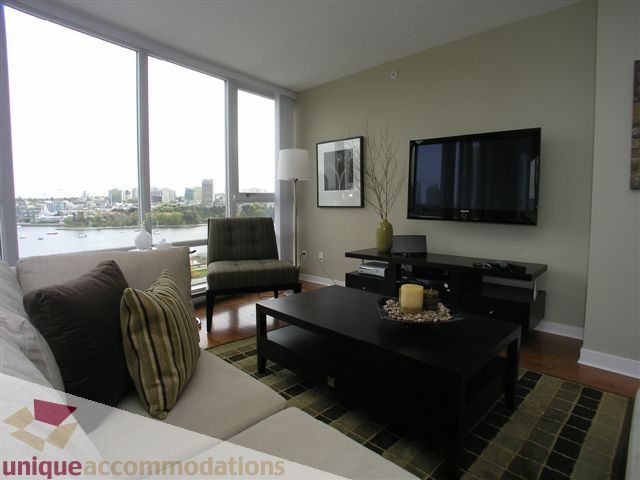 Spacious living room with a city view, modern furniture, and a large flat-screen TV. - 1008 - 1408 Strathmore Mews, Vancouver Downtown