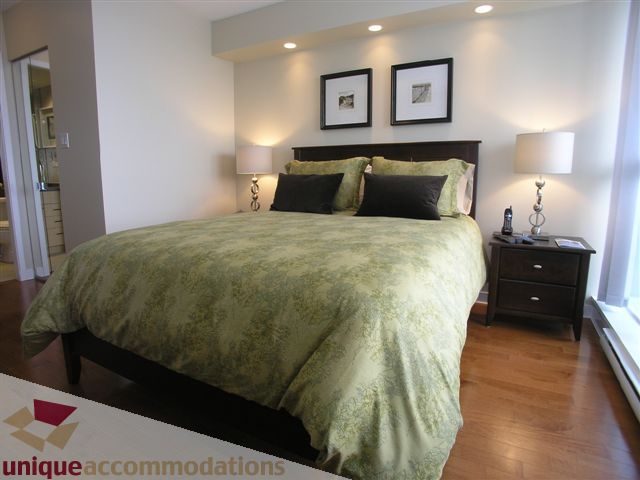 Spacious 2-bedroom condo with hardwood floors and a cozy green-themed bedroom. - 1008 - 1408 Strathmore Mews, Vancouver Downtown