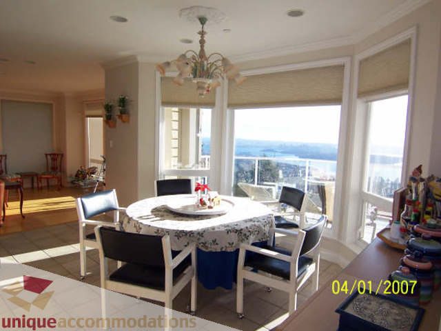 Bright dining area with city view and chandelier, hardwood floors. - 1659 Langton Place, West Vancouver