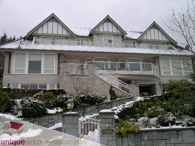 Spacious 5-bedroom house with snow-covered roof and stone walls. - 1659 Langton Place, West Vancouver