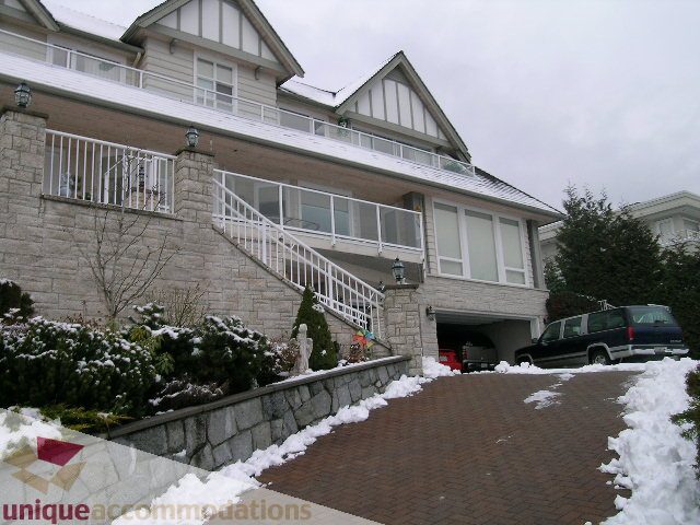 Furnished 5-bedroom house with snow-covered driveway and stone walls. - 1659 Langton Place, West Vancouver
