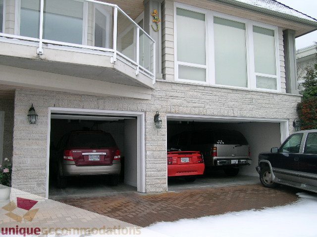 Spacious garage with open doors, revealing parked cars and storage space. - 1659 Langton Place, West Vancouver