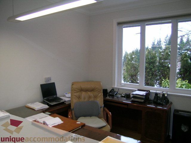 Furnished office space with large windows, natural light, and a desk setup. - 1659 Langton Place, West Vancouver