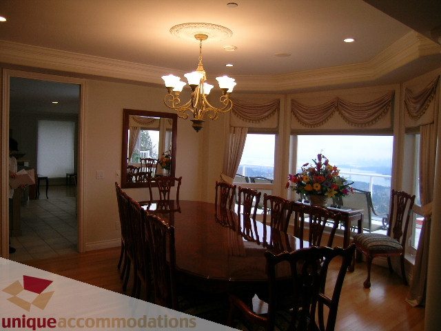 Elegant dining room with bay windows, hardwood floors, and a chandelier. - 1659 Langton Place, West Vancouver