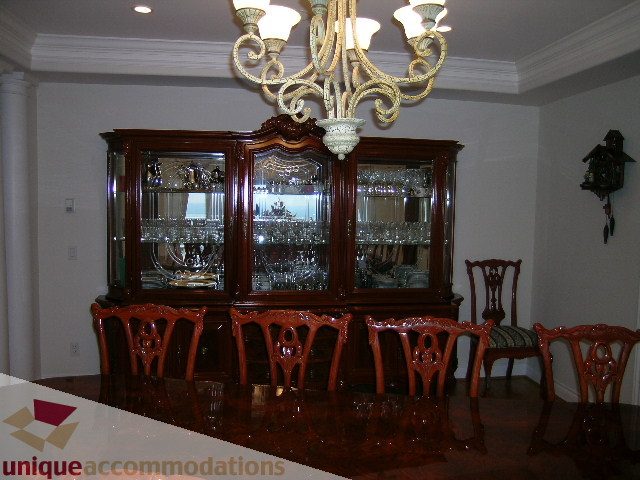 Formal dining room with ornate chandelier, dark wood furniture, and china cabinet. - 1659 Langton Place, West Vancouver