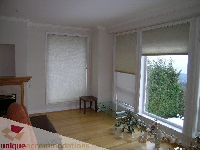 Bright living room with hardwood floors, large windows, and a fireplace. - 1659 Langton Place, West Vancouver