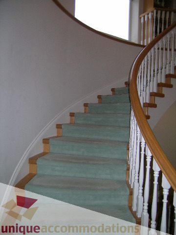 Staircase with wooden railings and carpeted steps leading to upper level. - 1659 Langton Place, West Vancouver