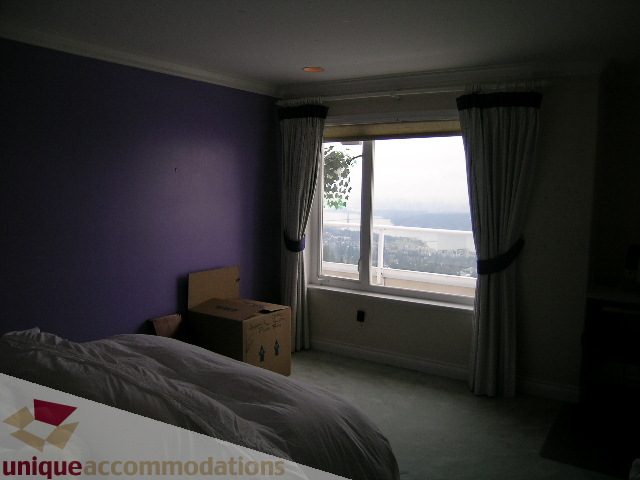Furnished bedroom with purple walls, city view, and large windows. - 1659 Langton Place, West Vancouver