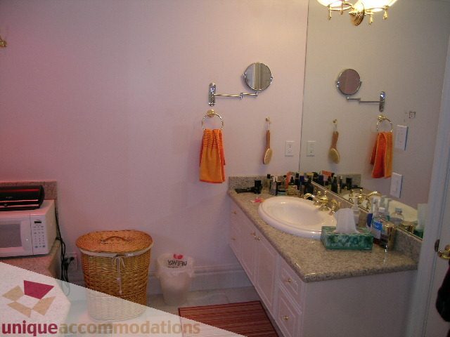 Furnished bathroom with granite countertops and orange towels. - 1659 Langton Place, West Vancouver