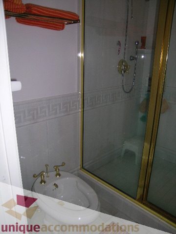 Bathroom with shower, sink, and decorative tile. - 1659 Langton Place, West Vancouver