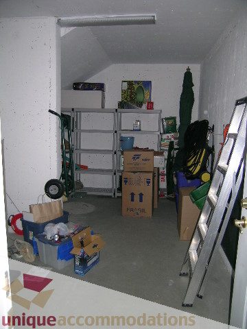 Cluttered basement with storage shelves and various items. - 1659 Langton Place, West Vancouver