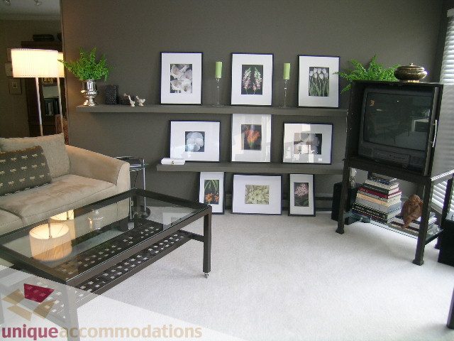 Furnished living room with modern decor, framed art, and a sleek coffee table. - 313-525 Wheelhouse Square, Vancouver West Side