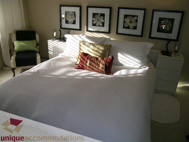 Furnished 1-bedroom condo with cozy bedding and floral artwork. - 313-525 Wheelhouse Square, Vancouver West Side