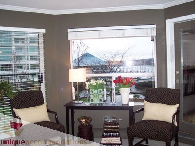 Bright living room with large windows, city view, and comfortable seating. - 313-525 Wheelhouse Square, Vancouver West Side