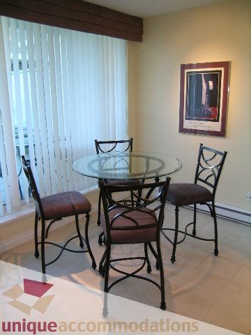 Bright dining area with glass table, metal chairs, and vertical blinds. - 305 - 1030 Quebec Street, Vancouver Downtown