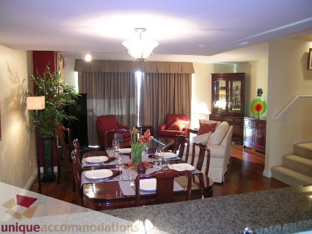 Furnished dining and living area with hardwood floors, granite countertops, and a chandelier. - 305 - 1030 Quebec Street, Vancouver Downtown