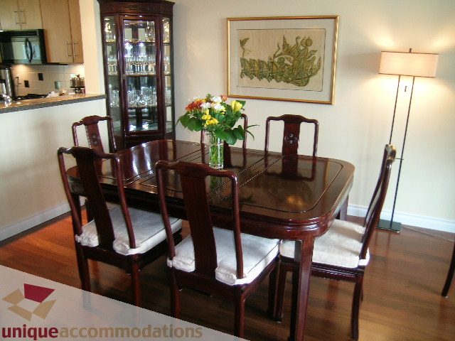 Furnished dining room with wooden chairs, hardwood floors, and a glass cabinet. - 305 - 1030 Quebec Street, Vancouver Downtown
