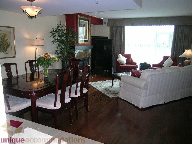 Furnished living and dining area with hardwood floors, white furniture, and a fireplace. - 305 - 1030 Quebec Street, Vancouver Downtown