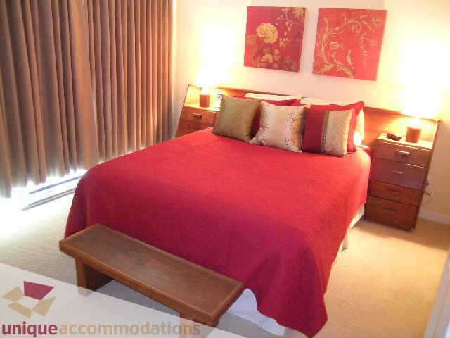 Furnished 3-bedroom townhouse with red bedding and wooden bench. - 305 - 1030 Quebec Street, Vancouver Downtown